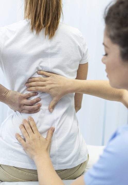 Physiotherapist doing healing treatment on womans back. Back pain patient, treatment, medical doctor, massage therapist.office syndrome